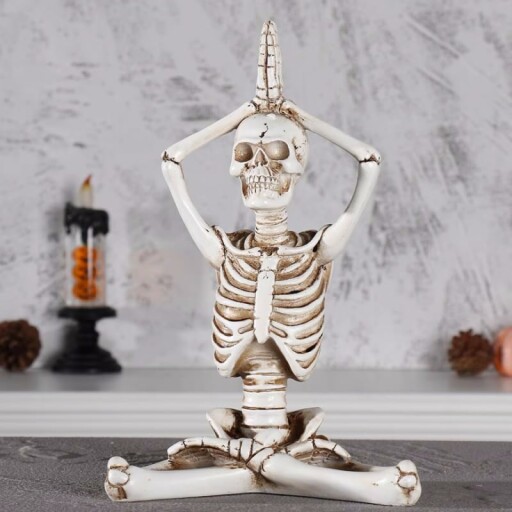 Yoga skeleton figurine in a serene pose.
