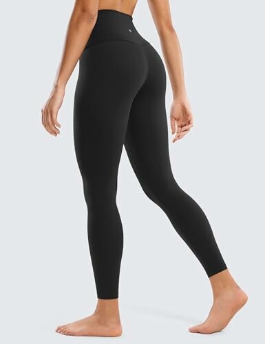 Woman wearing black high-waisted leggings, side view.