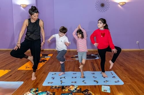 Instructor and children practicing yoga poses in a studio.