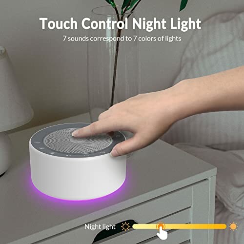 Hand reaching for a round touch control night light on a bedside table with a glowing purple base.